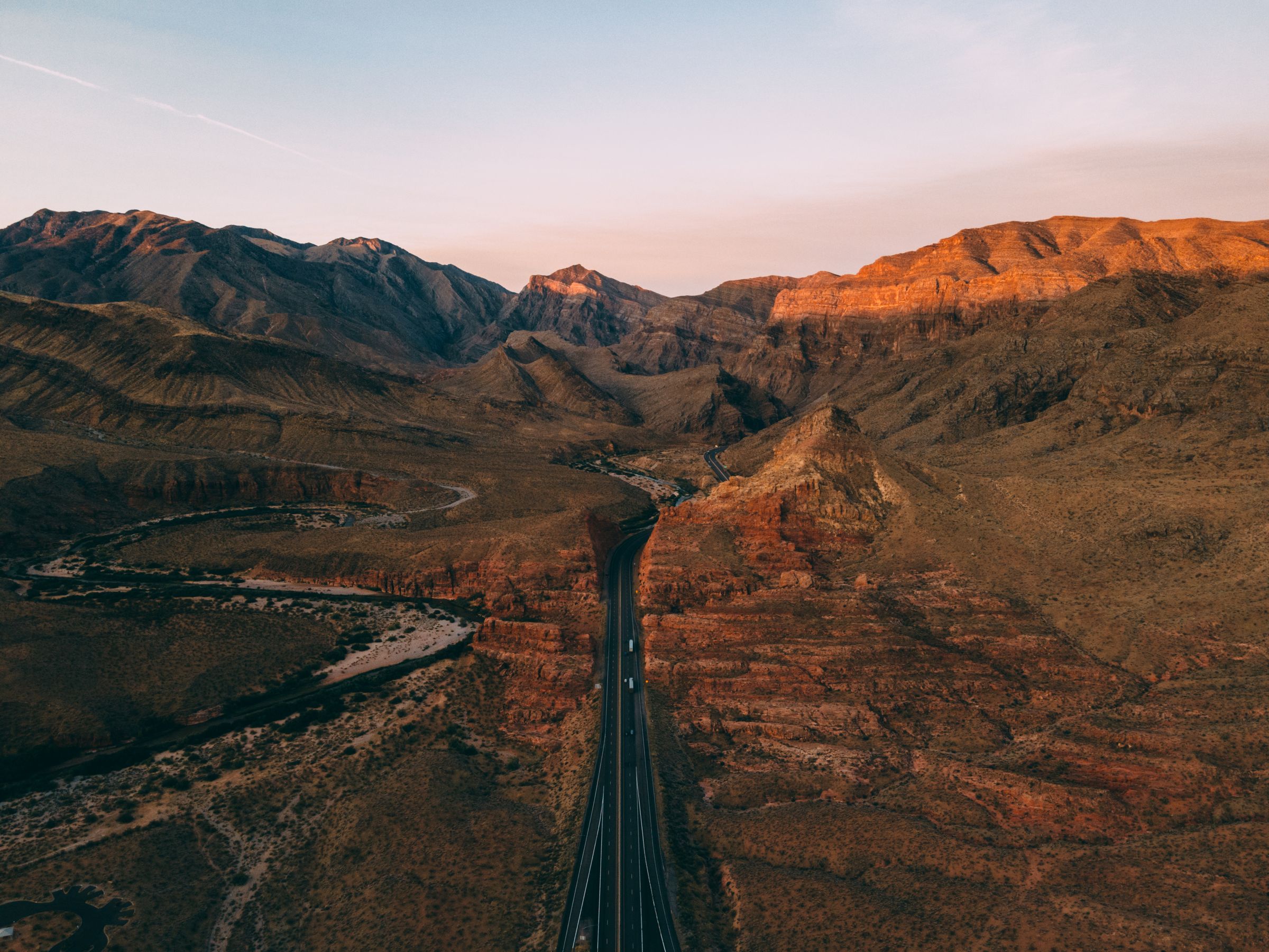 Aerial view of Arizona desert mountains and a winding road at sunset